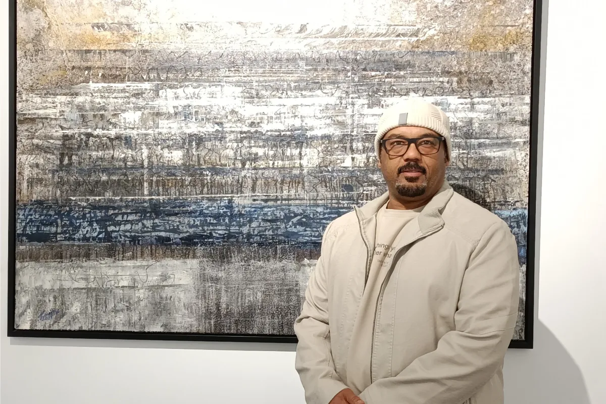 الفنان عادل العبيدي مع لوحته المعروضة في صالة إيقاع الفن