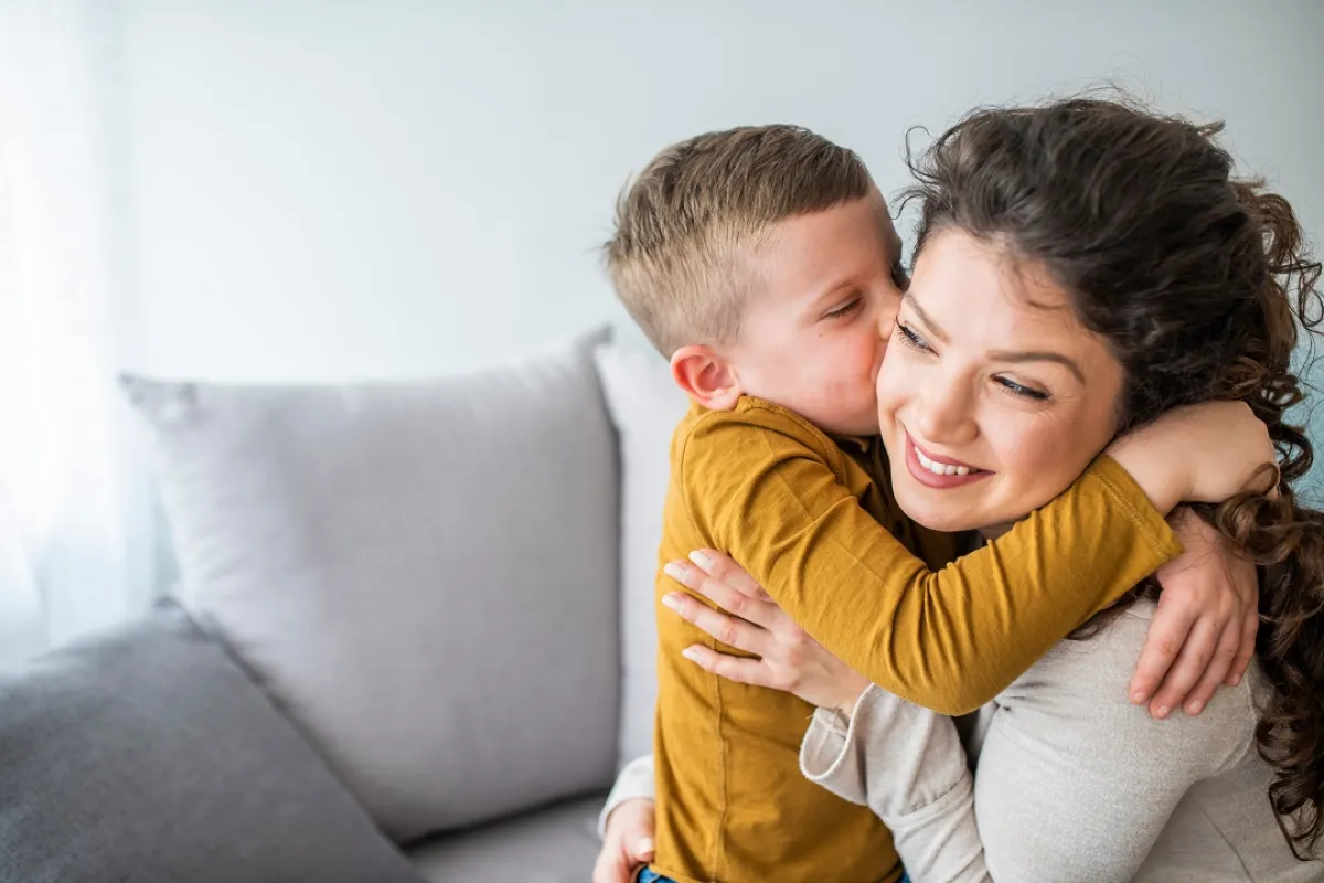 صورة لطفل يتشبث بحب وعناق أمه