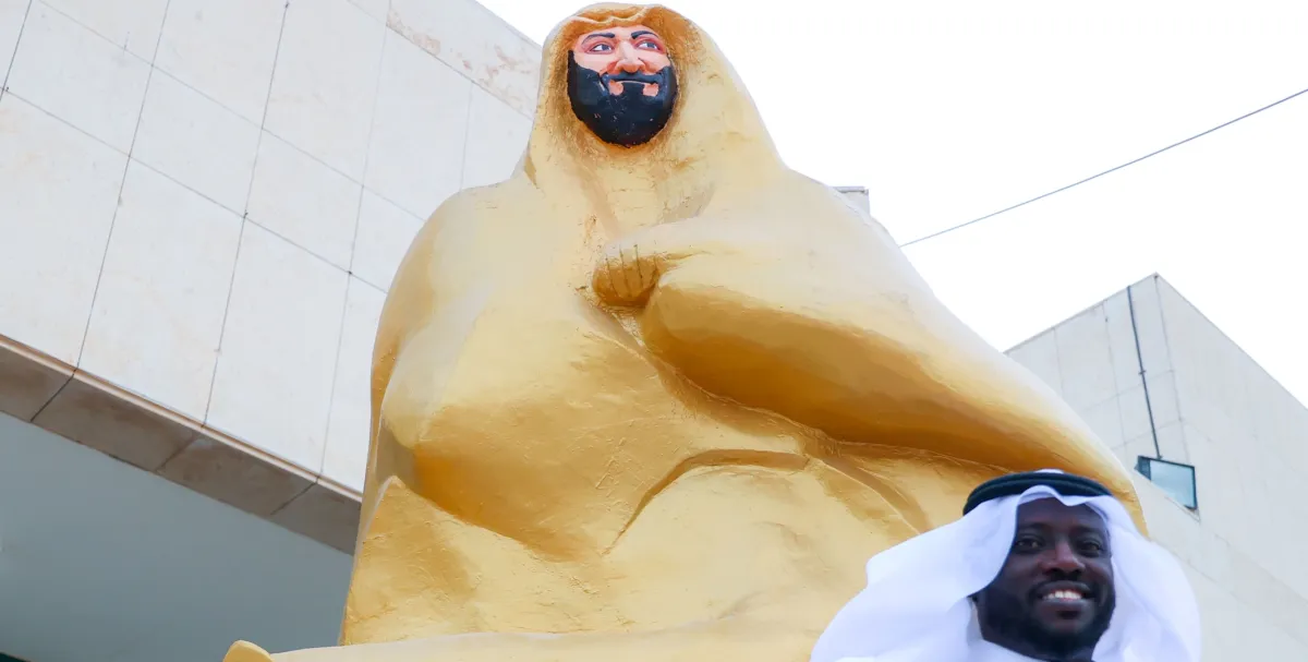 الفنان التشكيلي والنحات هاشم الجمعان يقف بجانب مجسم "محور العز" الذي قام بانجازة