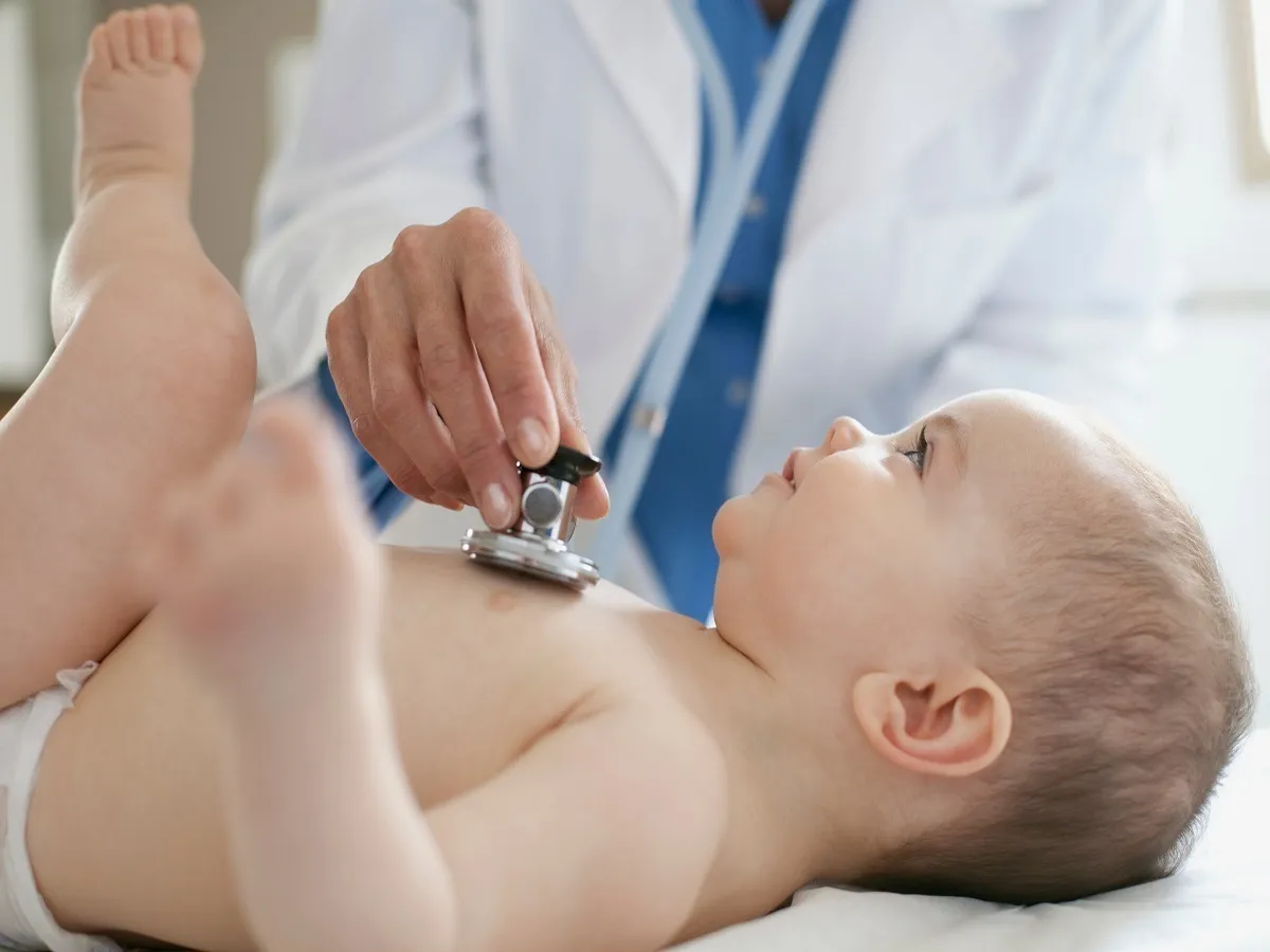 صورة لطبيب يفحص طفلاً رضيعاً