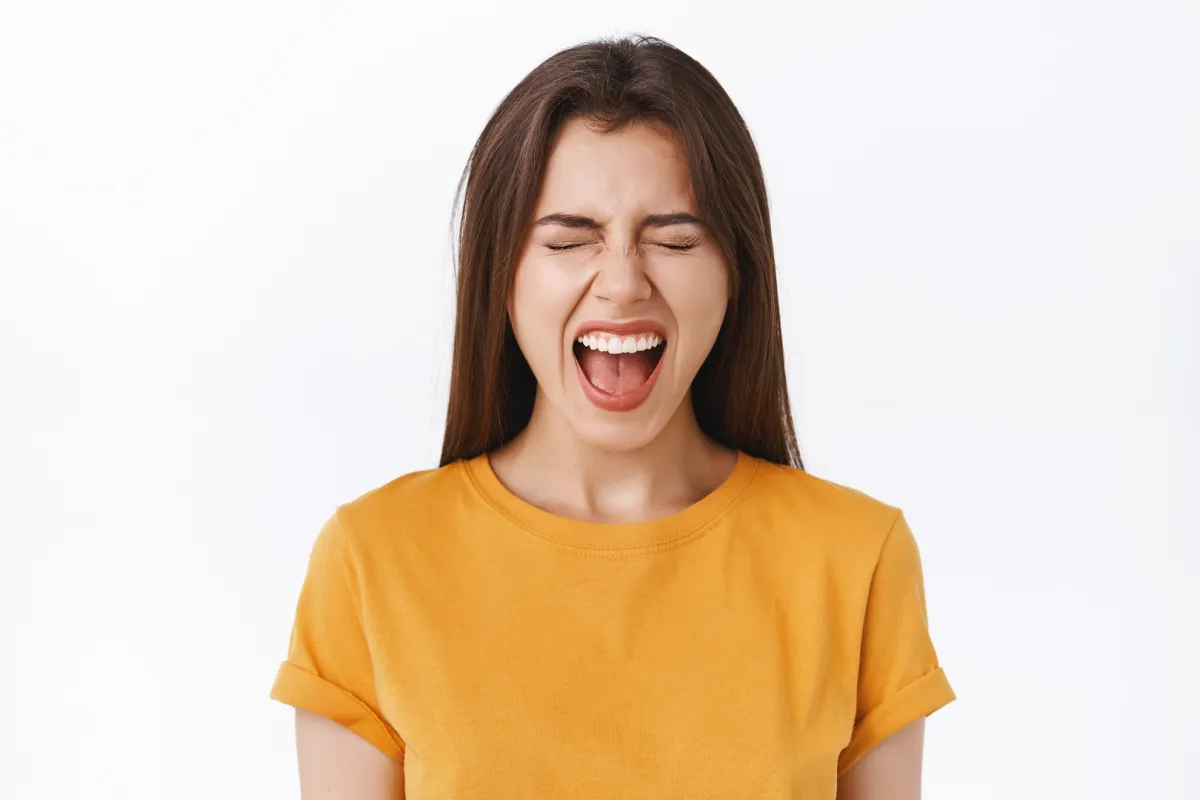 فتاة تعاني من ألم في اللسان نتيجة انتفاخه وإصابته بالالتهابات (المصدر: Adobe.Stock)