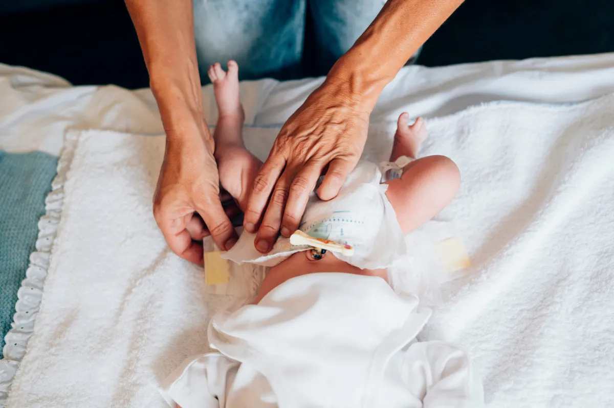 صورة لأم تضع الحفاض لرضيعها