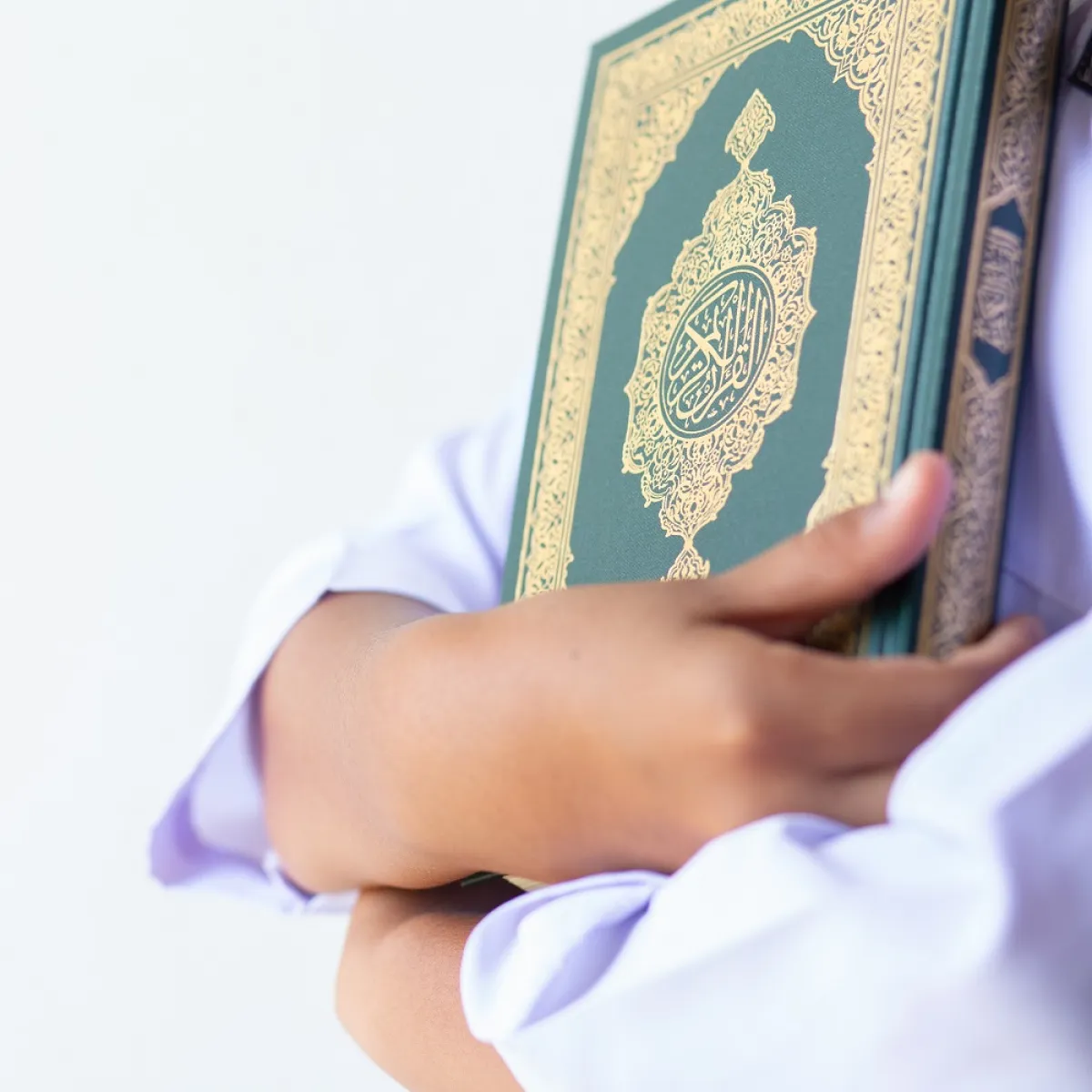 صورة لطفل يحتضن القرآن