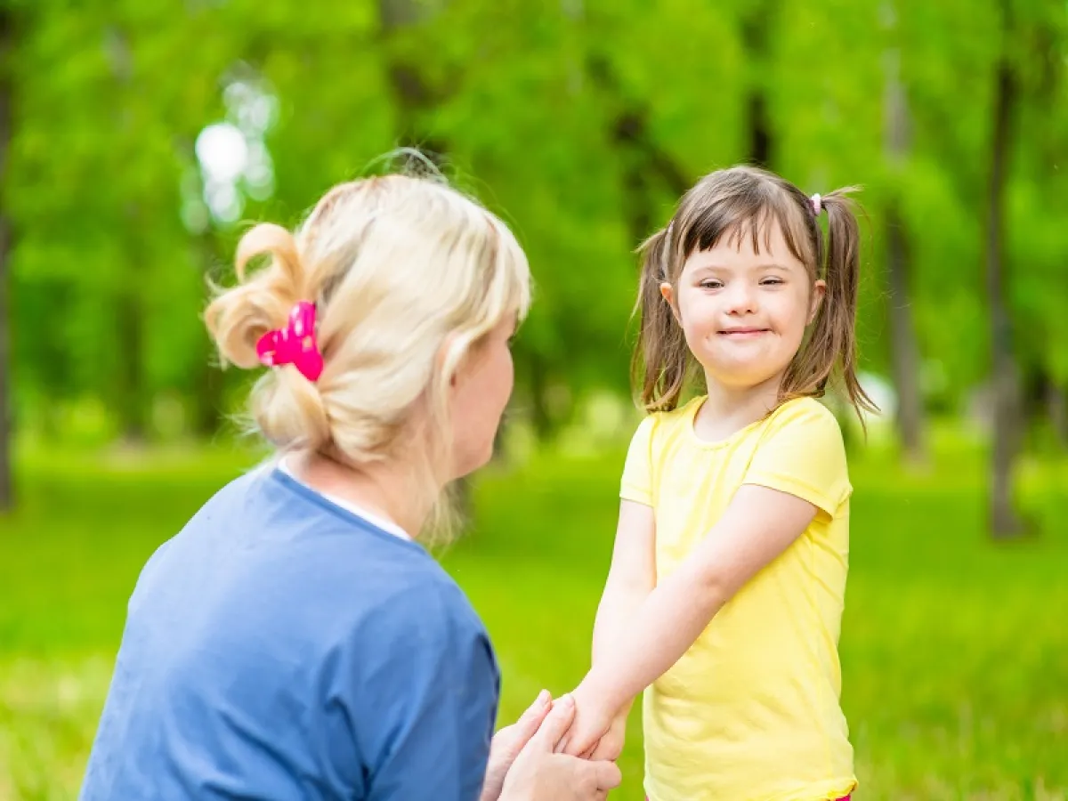 طفلة مصابة بمتلامة داون مع والدتها في الحديقة (المصدر: Adobe.Stock)