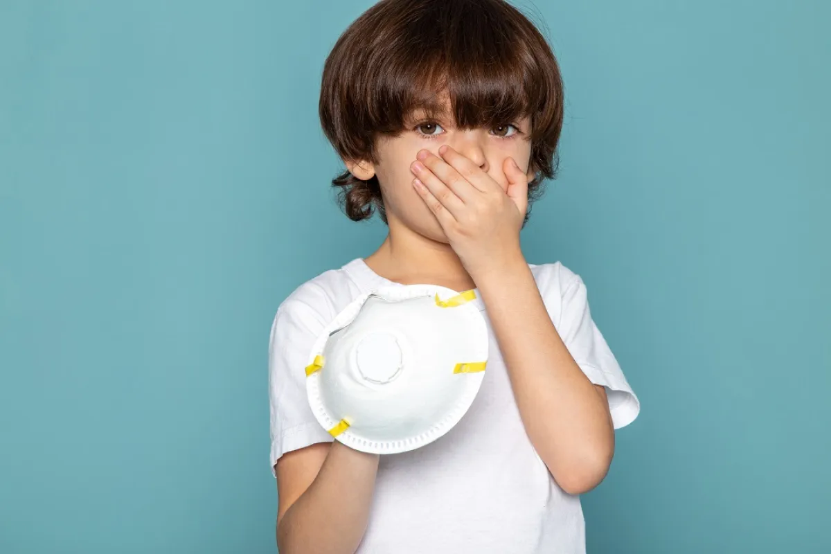 صورة لطفل يضع يده على فمه