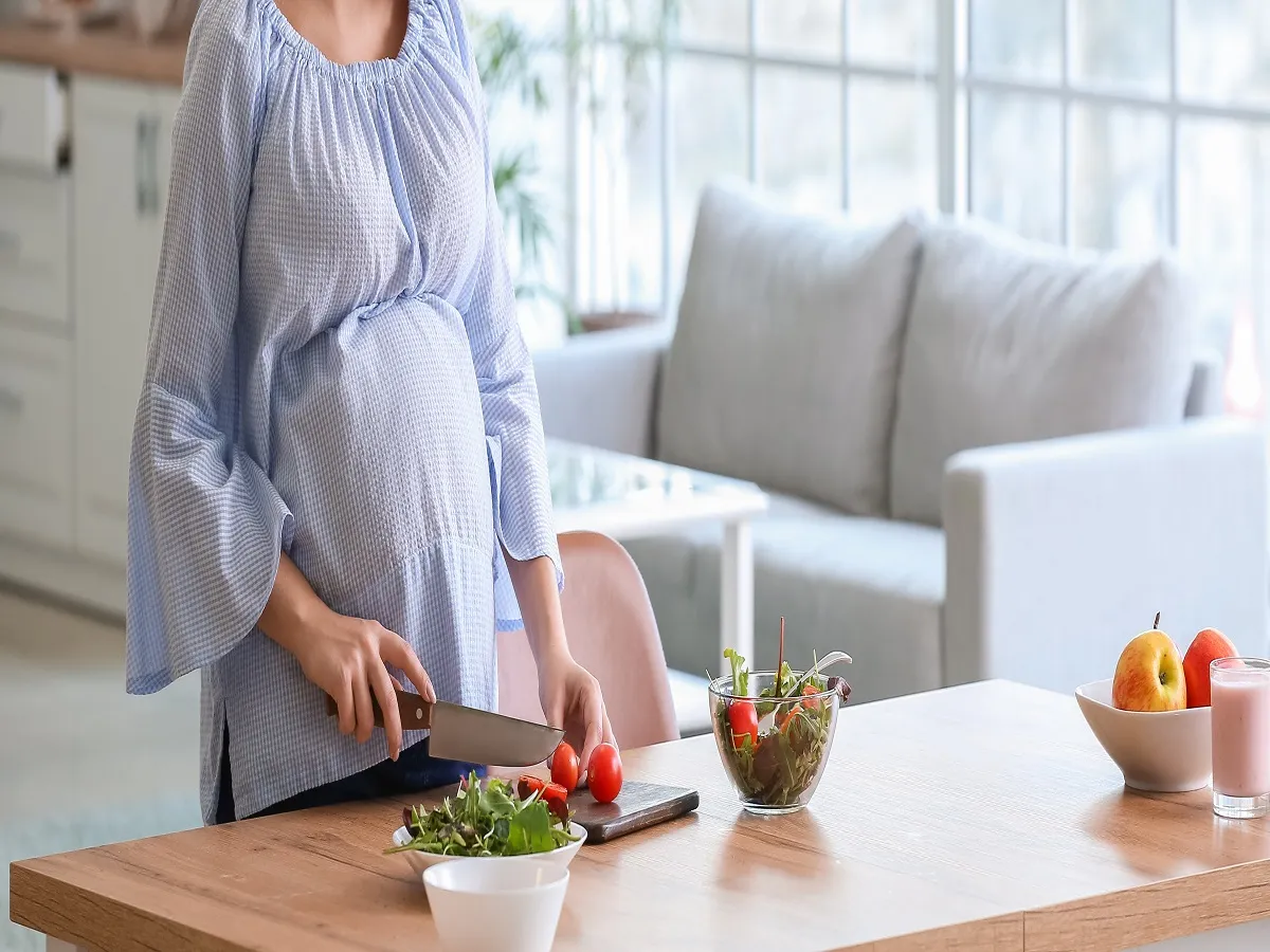 صورة لامرأة حامل تحضر الطعام