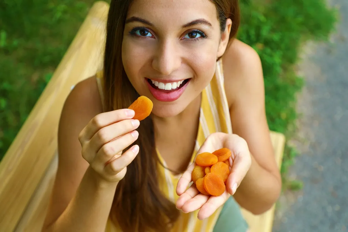 صورة لحامل تتناول المشمش المجفف