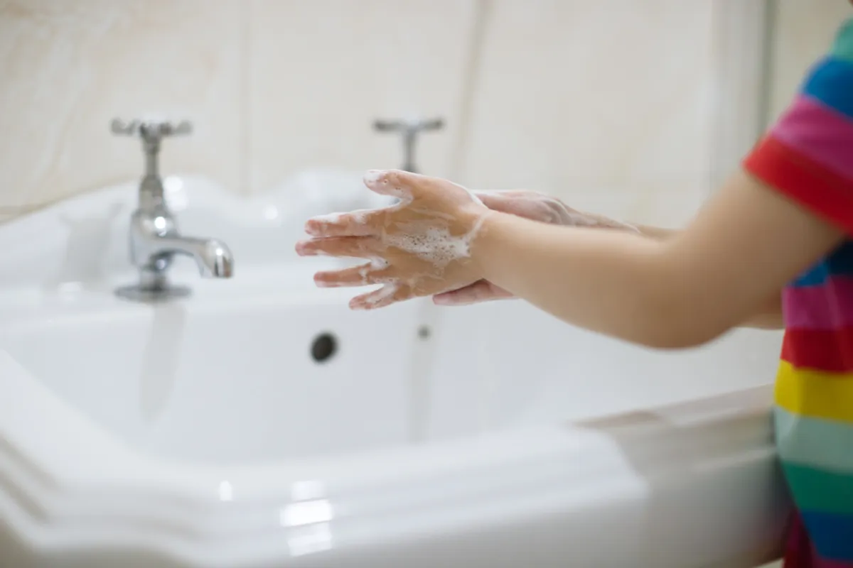 صورة طفل يغسل يديه