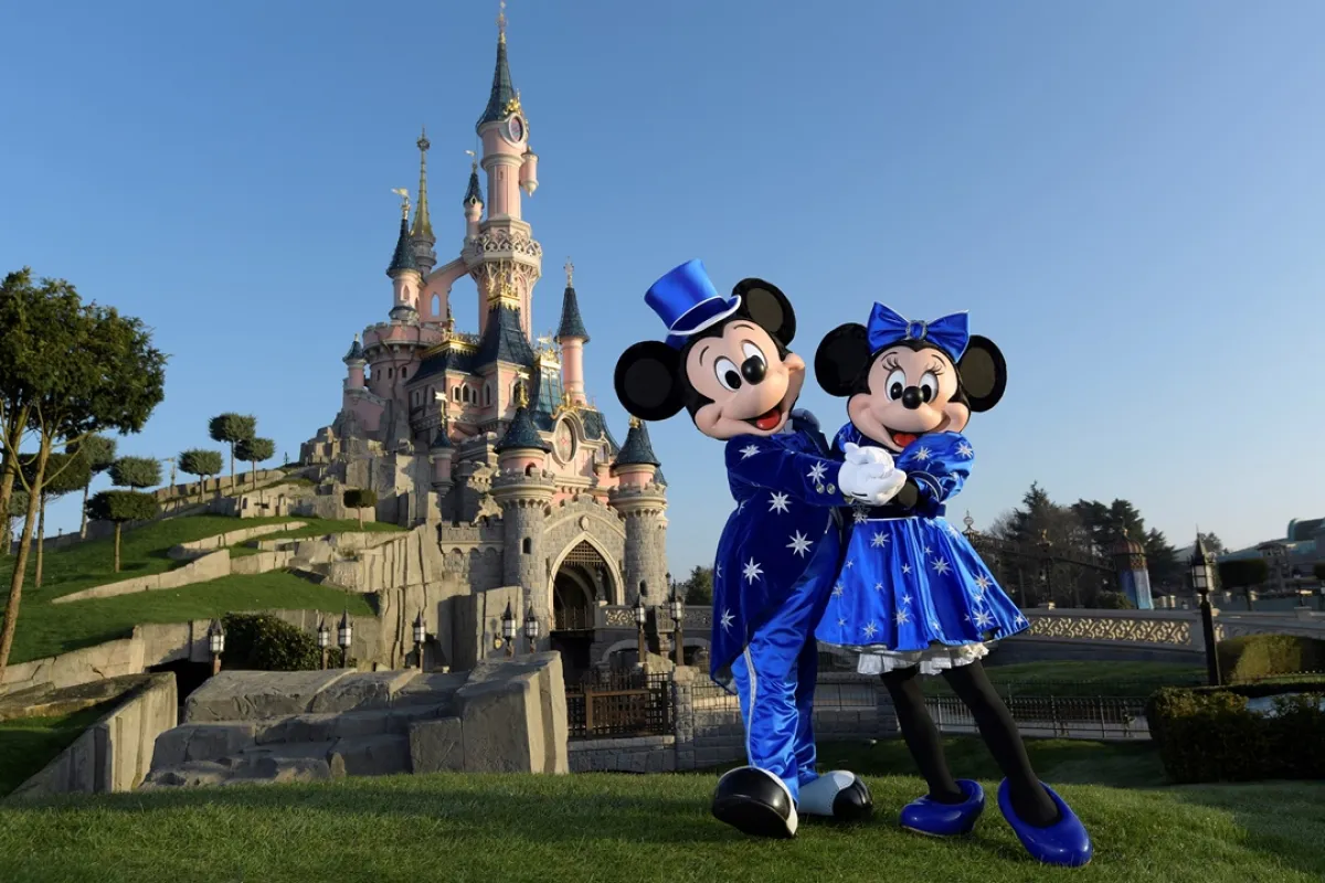 Disney characters Mickey and Mini mouse pose in front of the Sleeping Beauty Castle to mark the 25th anniversary of Disneyland - originally Euro Disney Resort - on March 16, 2017 in Marne-La-Vallee, east of the French capital Paris. BERTRAND GUAY / AFP