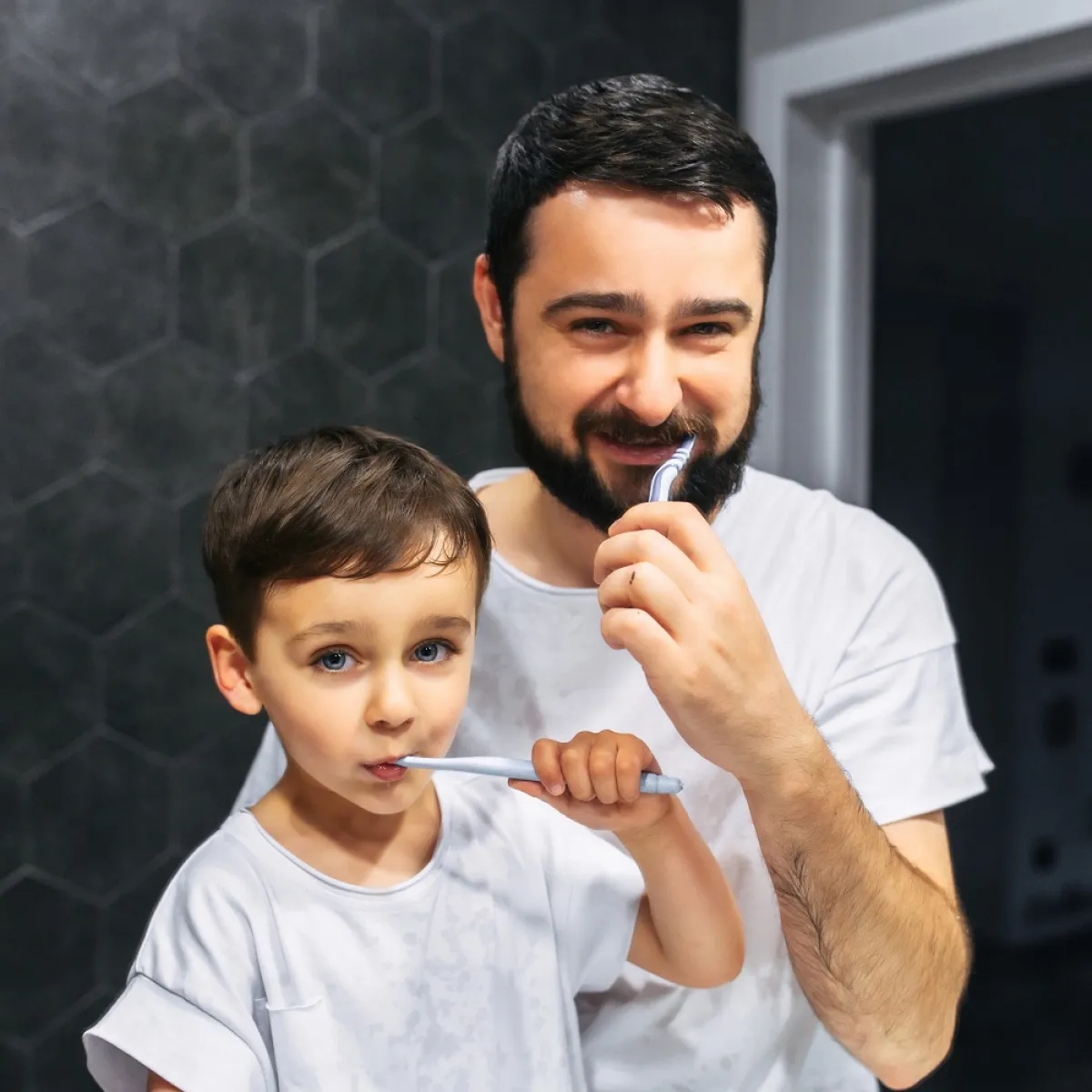 صورة لطفل ووالده ينظفان أسنانهما