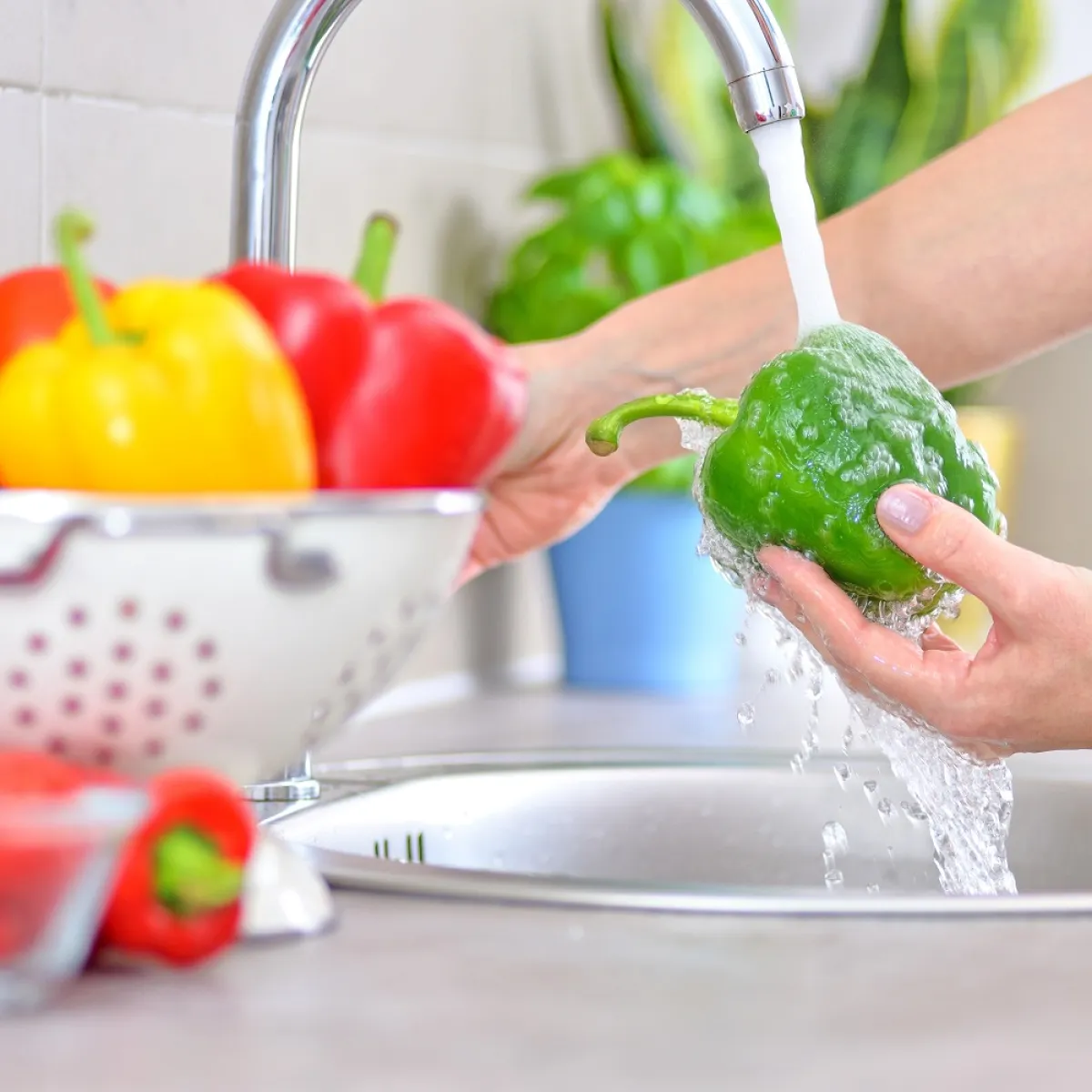 صورة لأم تغسل الخضروات بالماء