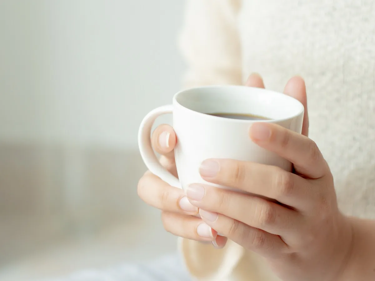 صورة لامرأة تحمل كوب من الشاي