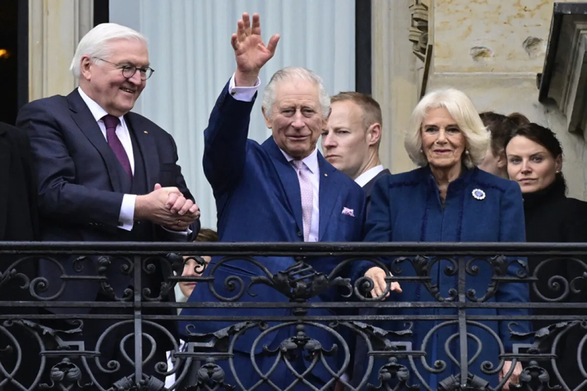 Britain's King Charles III (L) and Britain's Camilla (R), Queen Consort, greet wellwishers from the balcony of the city Hall, in Hamburg, northern Germany on March 31, 2023. Britain's Royal Couple is on a three-day tour in Germany for Charles' first state visit as king, with the trip billed as "an important European gesture" to maintain strong ties after Brexit. John MACDOUGALL / AFP