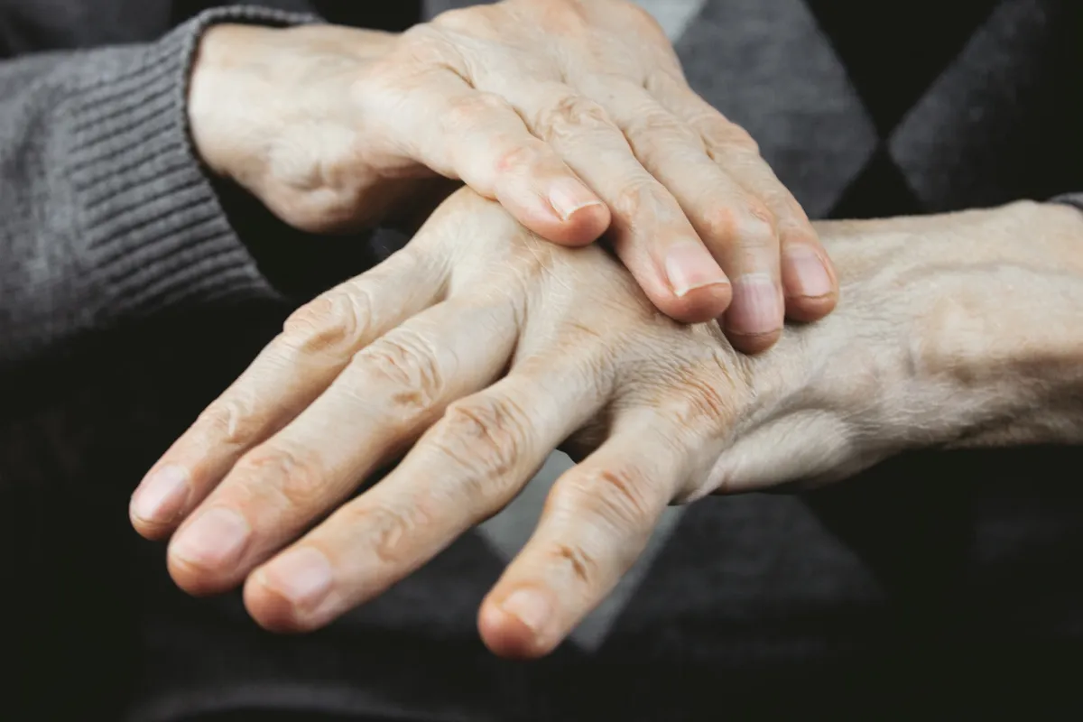 عجوز تعاني من الرعاش وتصلب العضلات وتيبسها نتيجة الإصابة بمرض باركنسون (المصدر: Adobe.Stock)