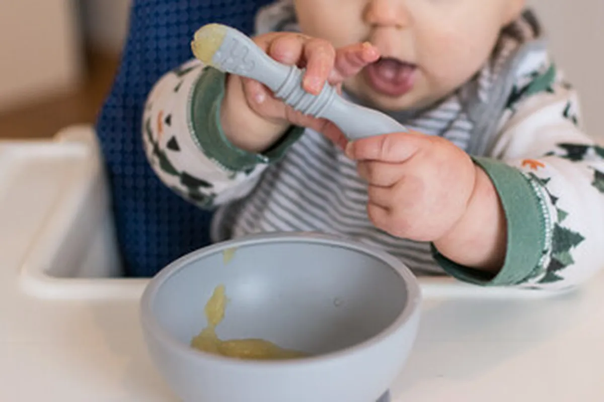 صورة تشير لرضيع يتناول التفاح المهروس