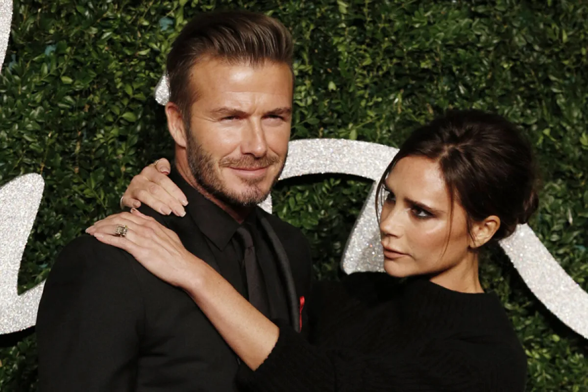David Beckham and his wife British fashion designer and singer Victoria pose for pictures on the red carpet upon arrival to attend the British Fashion Awards 2014 in London on December 1, 2014. AFP PHOTO/JUSTIN TALLIS