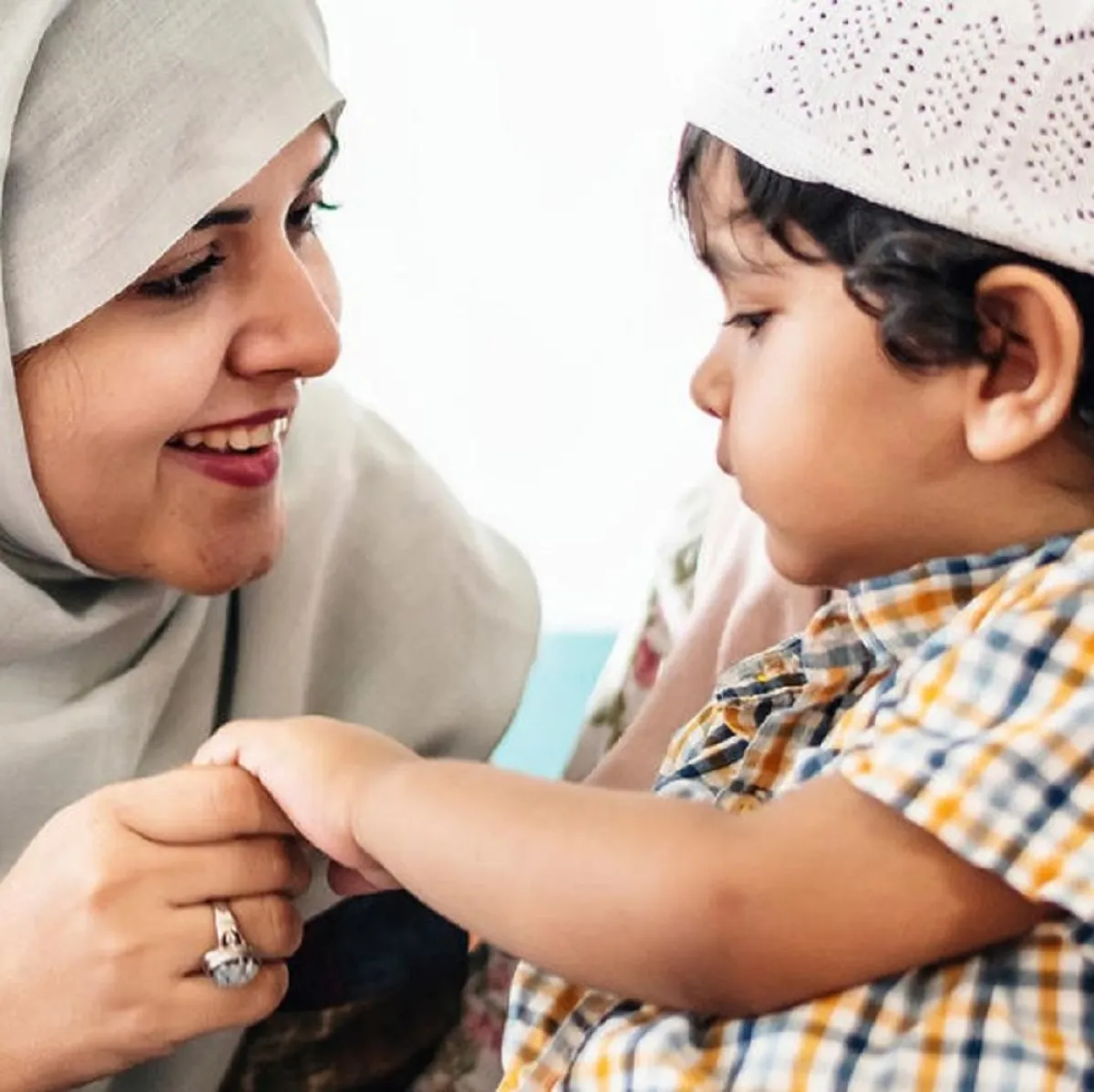 صورة لأم تشرح لطفلها آداب الصلاة بالمسجد