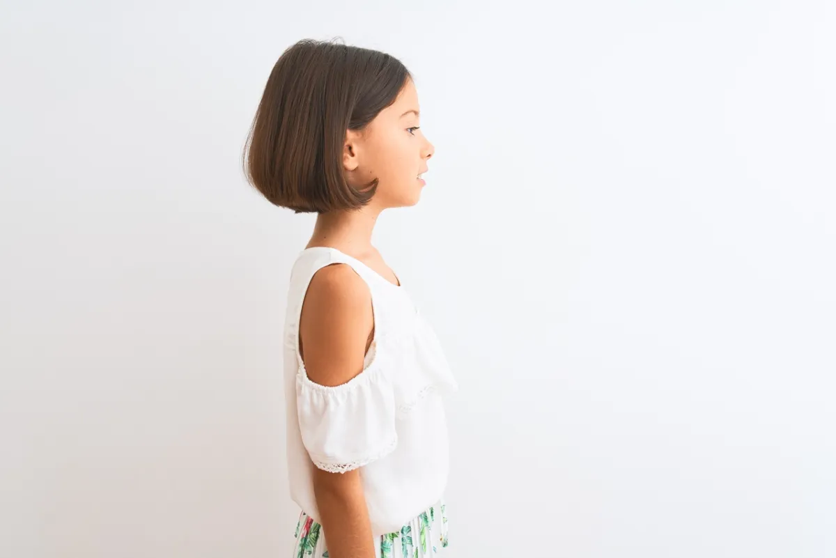 صورة فتاة بفستان يبدو مثل بلوزة بيضاء وتنورة ملونة