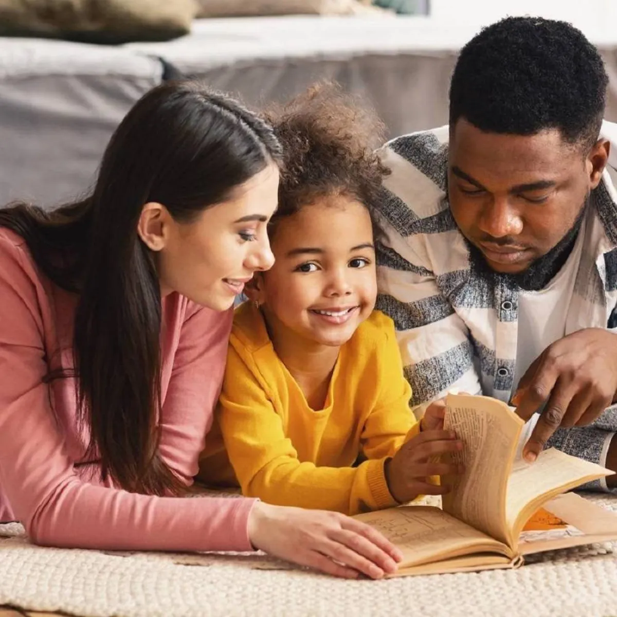 صورة لطفلة تستمع لقصة من والديها