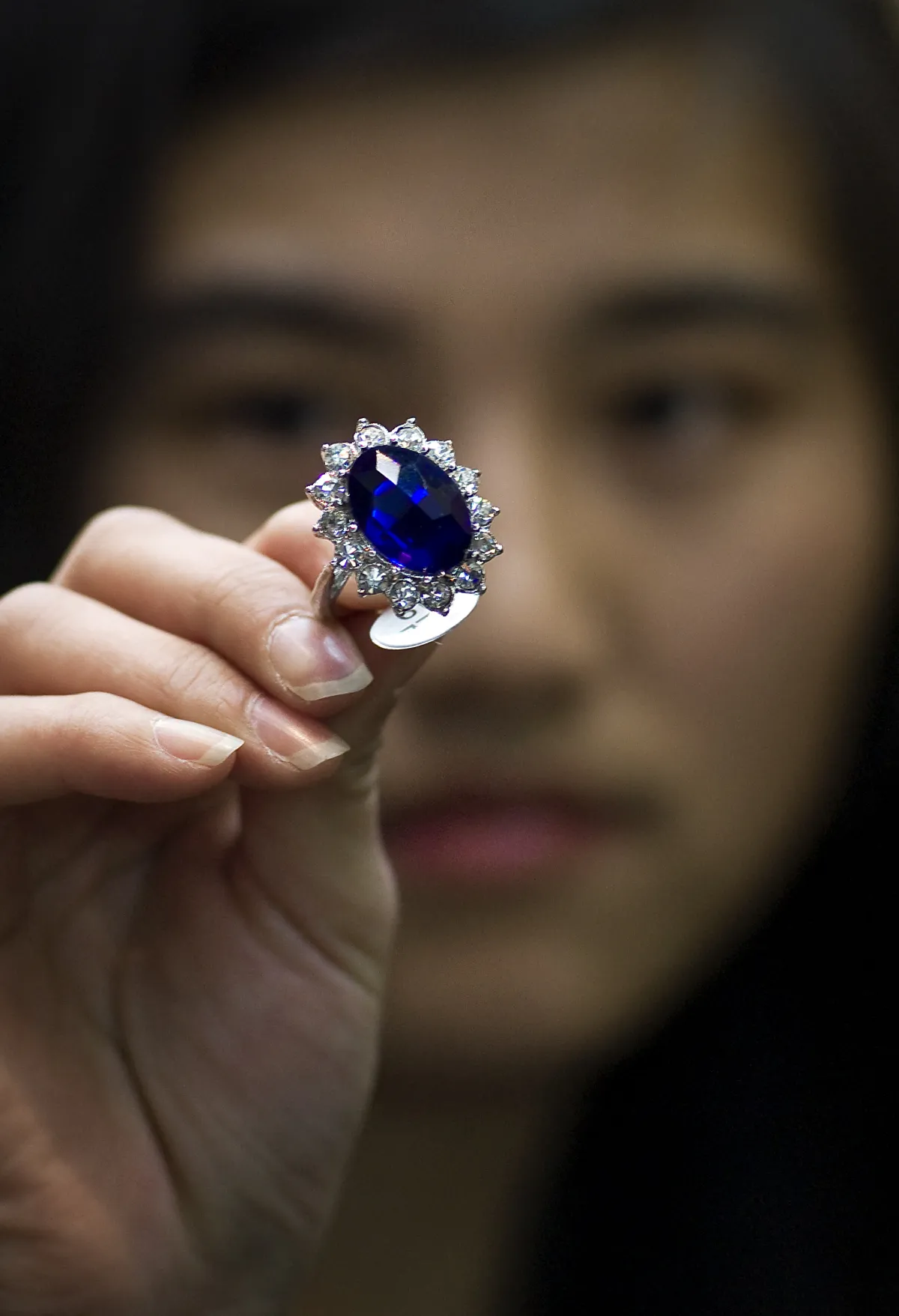 In this picture taken on April 12, 2011 in Yiwu, a Chinese woman holds a replicas of the blue 18-carat sapphire and diamond engagement ring that once belonged to Princess Diana and which Prince William offered to Kate Middleton when he proposed. AFP PHOTO/Philippe Lopez
