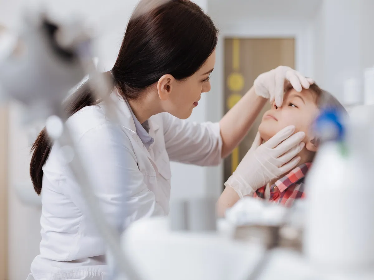 صورة لطبيبة تفحص أنف طفل