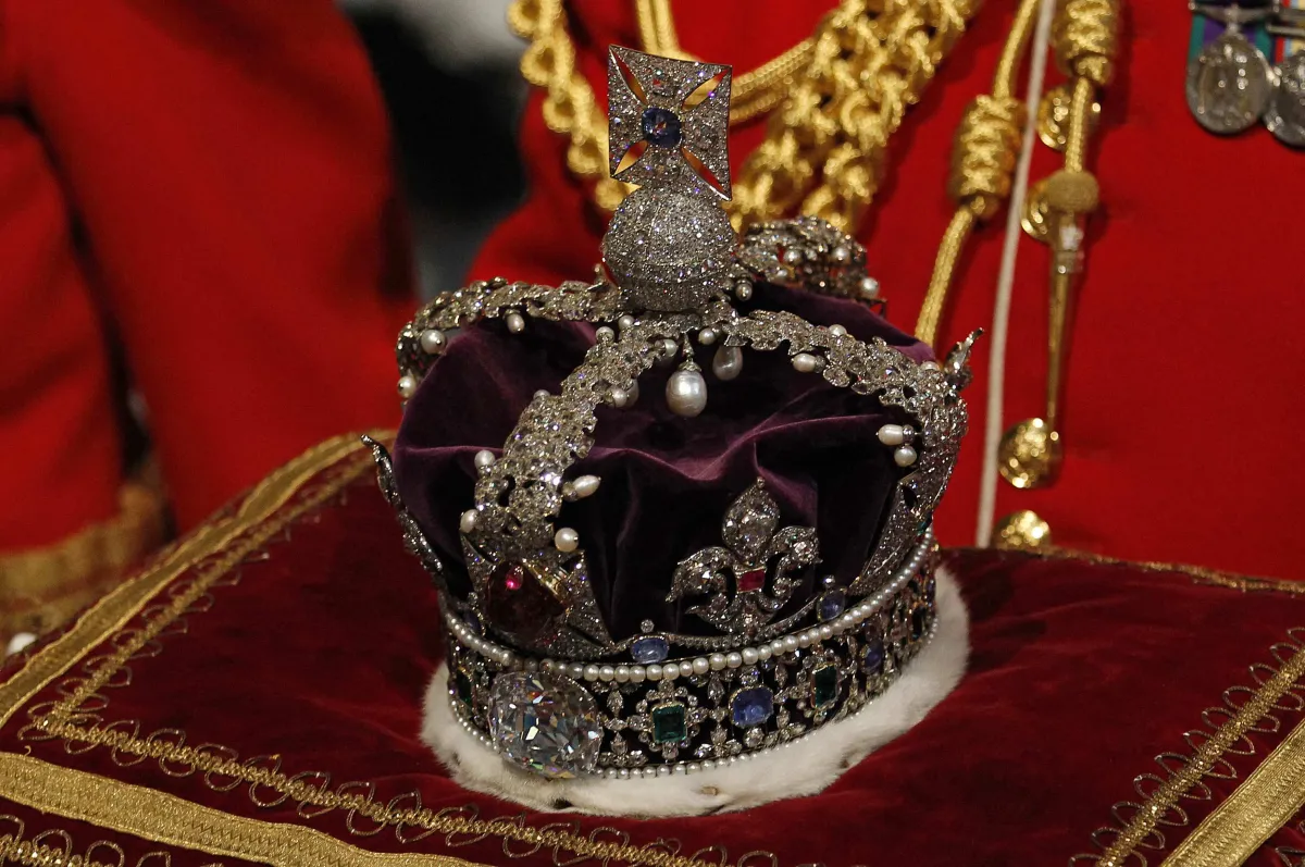 The Imperial State Crown is carried through the Norman Porch of the Palace of Westminster as it arrives for the State Opening of Parliament in London May 9, 2012. Britain's Queen Elizabeth II unveiled the coalition government's legislative programme in a speech delivered to Members of Parliament and Peers in the House of Lords. AFP PHOTO / POOL / SUZANNE PLUNKETT SUZANNE PLUNKETT / POOL / AFP