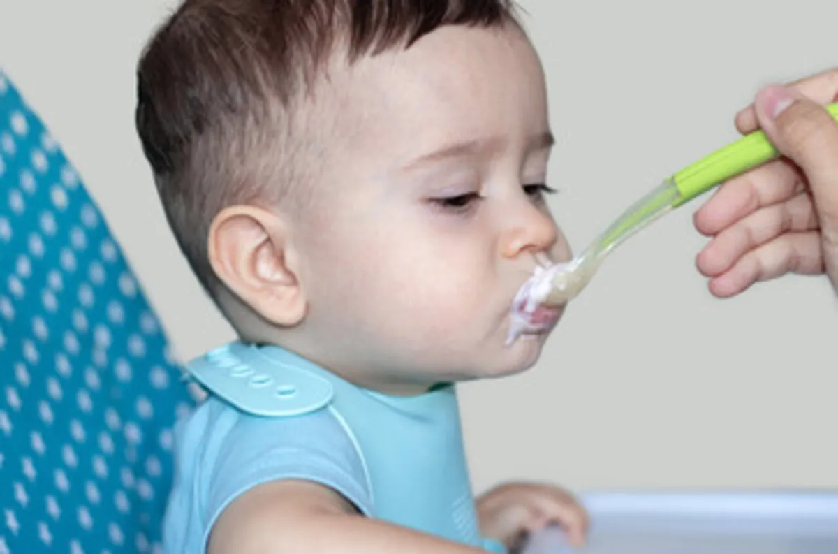 صورة لام تطعم طفلها اللبن الزبادي