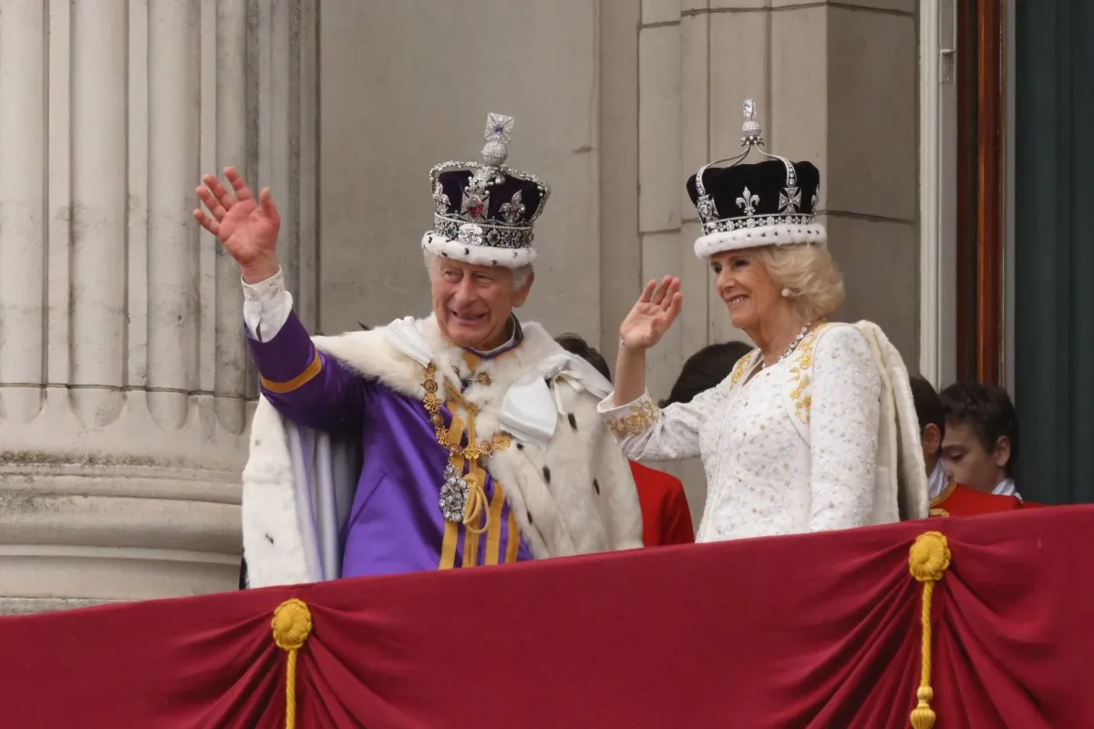 King Charles III and Queen Camilla wave from the Buckingham Palace balcony in central London on May 6, 2023. (Photo by Daniel LEAL / AFP)