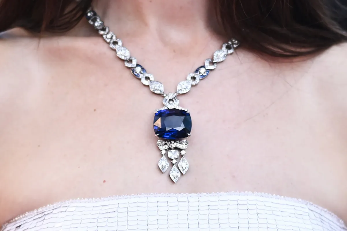 A photo shows the necklace worn by US actress Anne Hathaway as she arrives for the screening of the film "Armageddon Time" during the 75th edition of the Cannes Film Festival in Cannes, southern France, on May 19, 2022. (Photo by LOIC VENANCE / AFP)