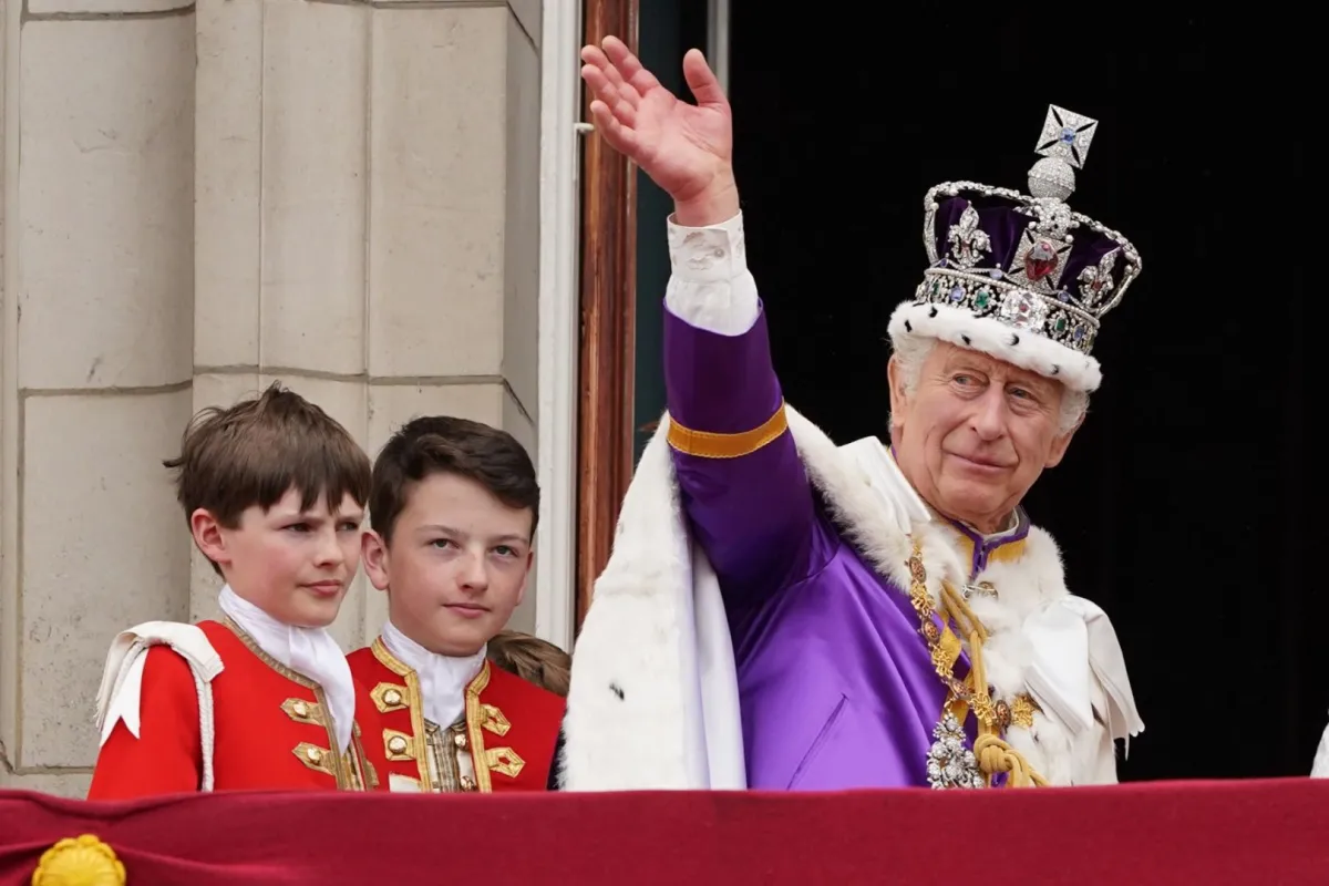 King Charles III waves from the Buckingham Palace balcony in central London on May 6, 2023, after his coronation. (Photo by Stefan Rousseau / POOL / AFP)