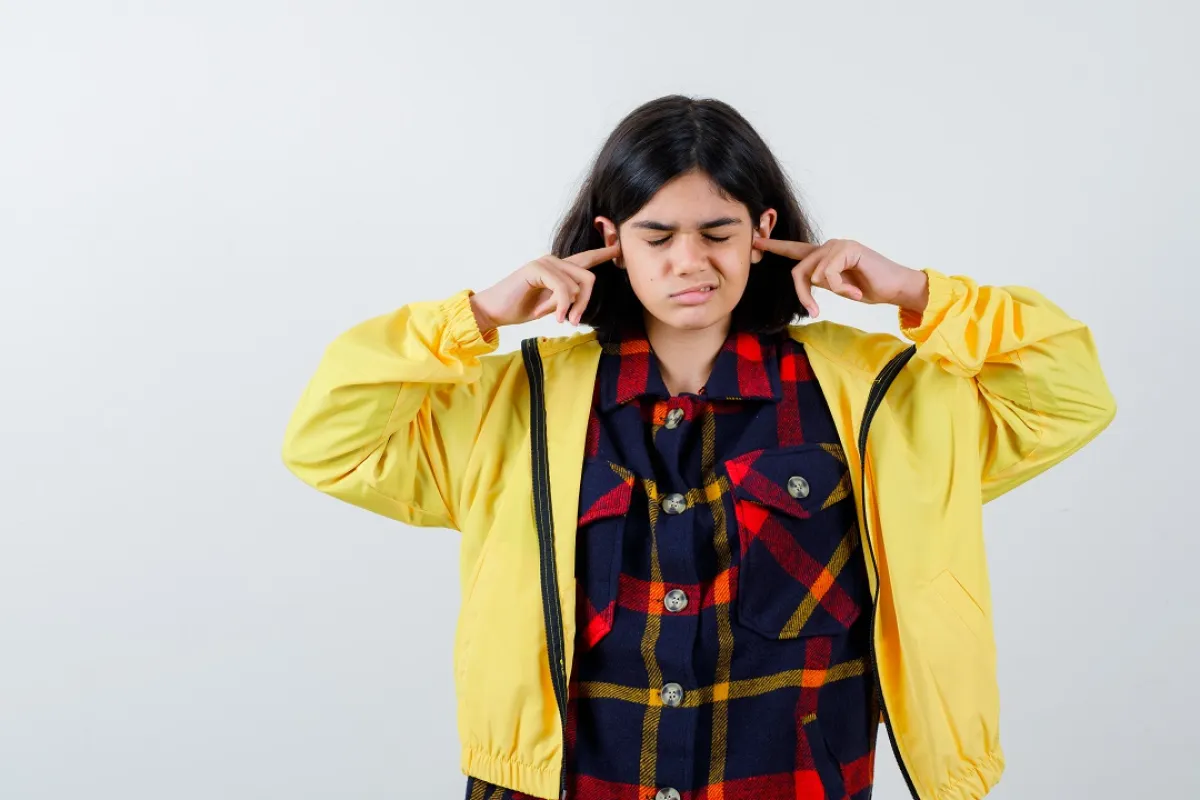 صورة لمراهقة تضع يديها في اذنها