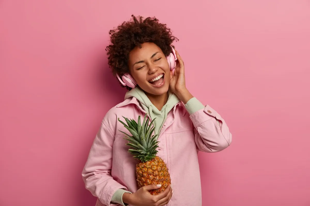 صورة لحامل تمسك بثمرة الأناناس