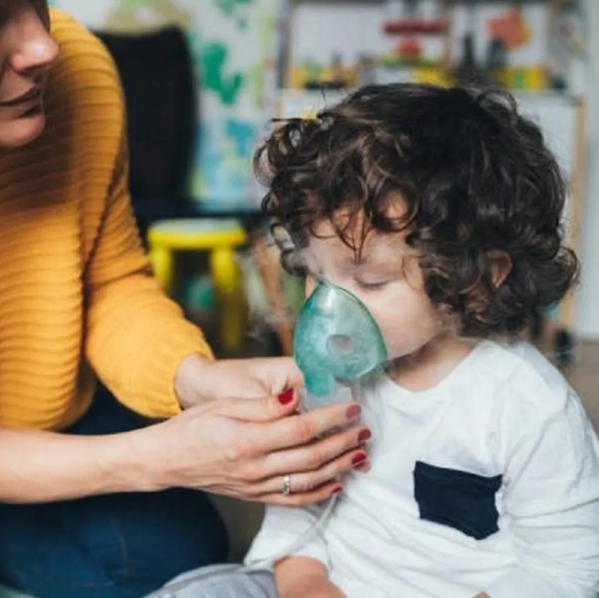 صورة لأم وطفلة تستخدم جهازاً للتنفس