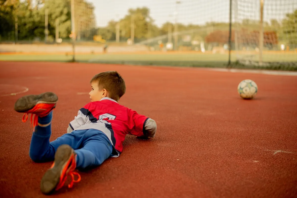 صورة لطفل يقع داخل الملعب