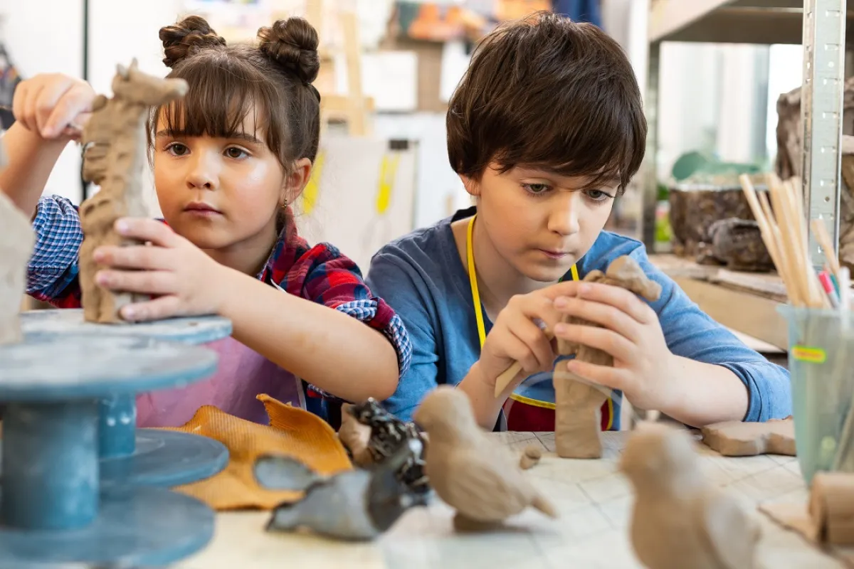 صورة لطفلين يلعبان بالصلصال والطين باهتمام