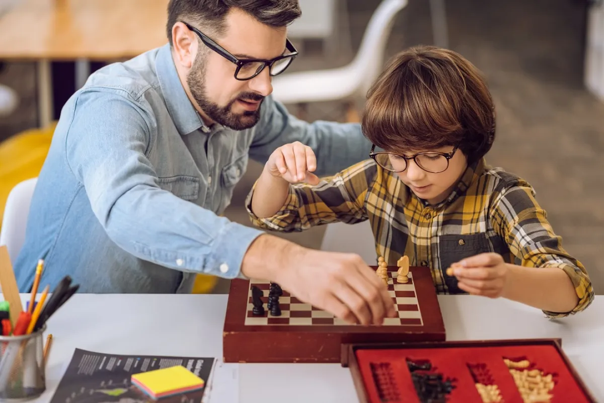 صورة لأب يعلم طفله الشطرنج