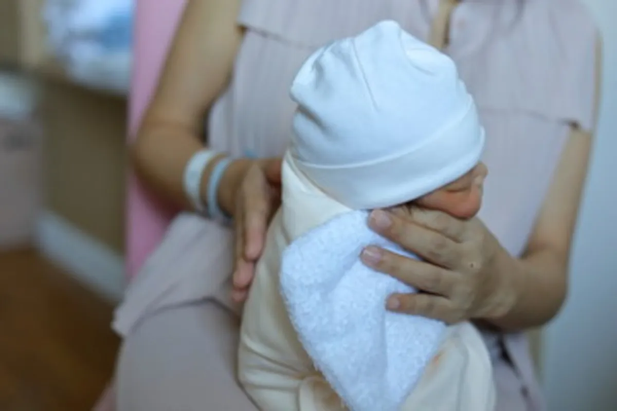 صورة لأم تكرع رضيعها وهو نائم