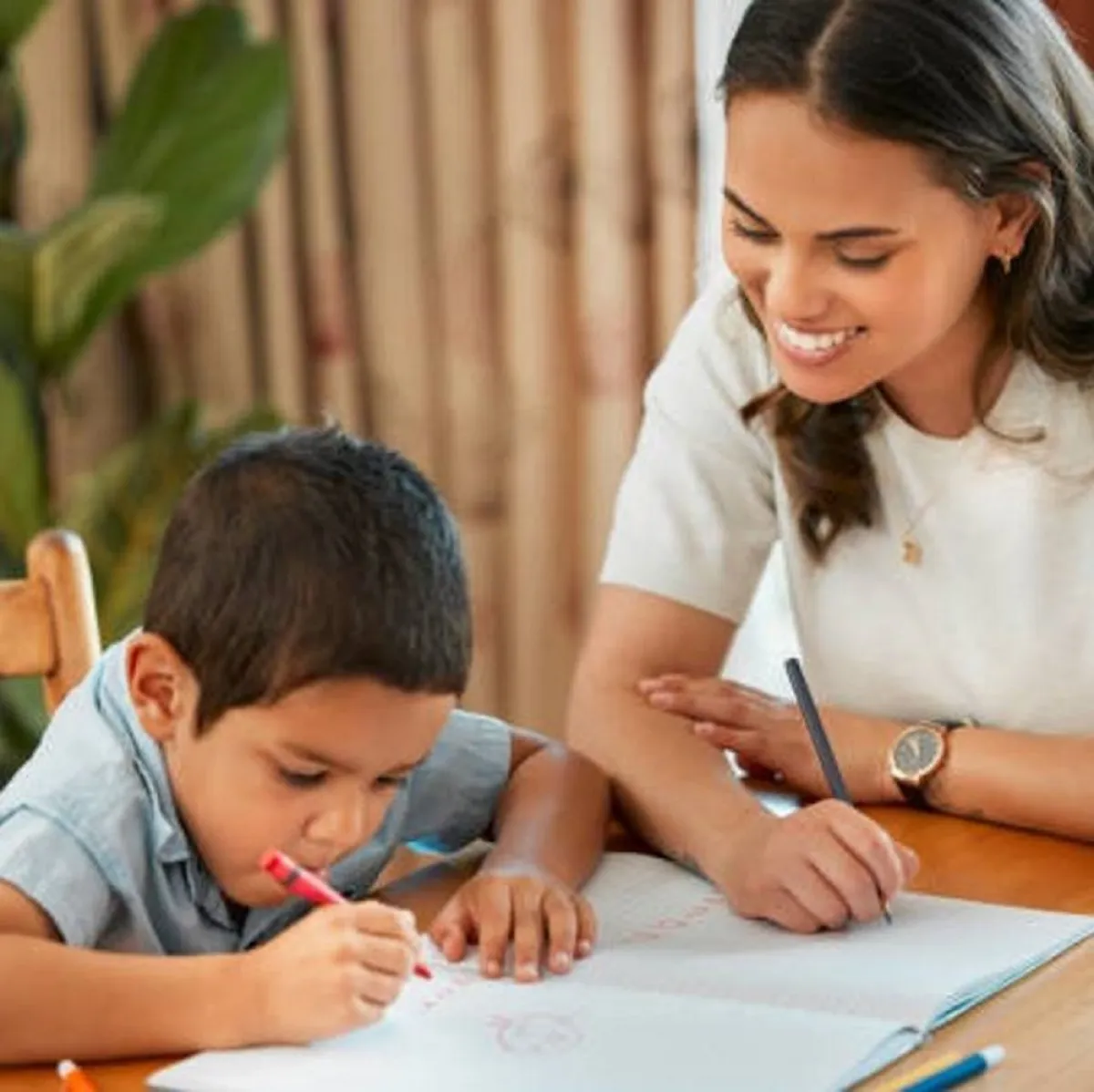 صورة لطفل يكتب وأمه ترعاه