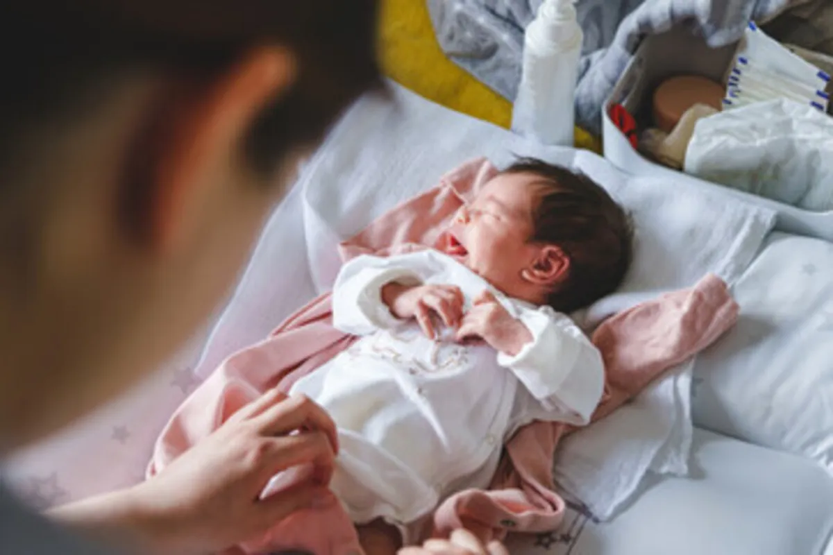 صورة لام تغير خفاض المولود وهي واقفة