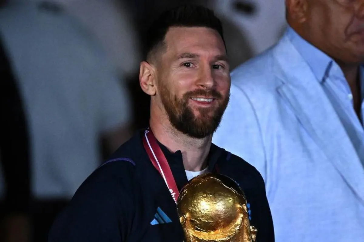 Argentina's captain and forward Lionel Messi (C) holds the FIFA World Cup Trophy upon arrival at Ezeiza International Airport after winning the Qatar 2022 World Cup tournament in Ezeiza, Buenos Aires province, Argentina on December 20, 2022. Luis ROBAYO / AFP