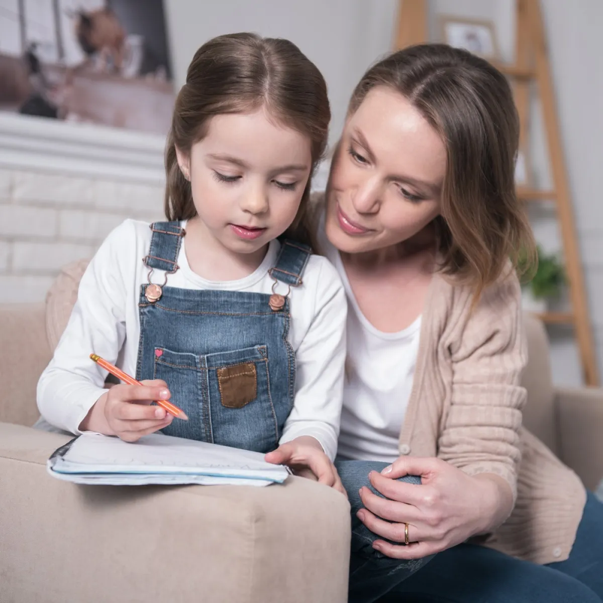 صورة لأم تعلم طفلتها الحروف