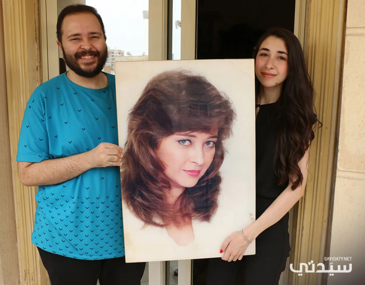 ليلى وشقيقها يوسف منير يحملان صورة والدتهما فايزة كمال- تصوير- عمرو فارس
