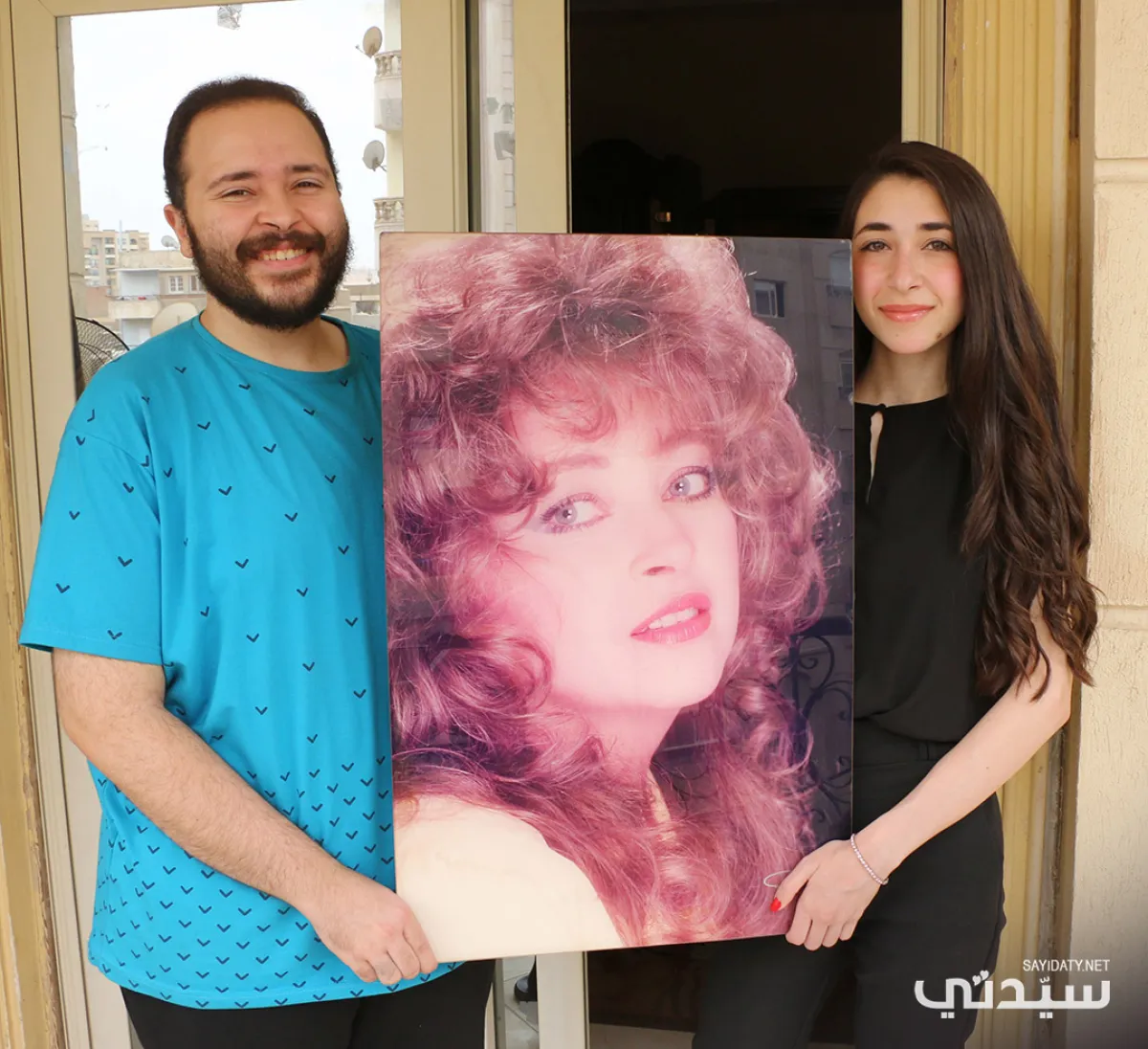 ليلى وشقيقها يوسف منير يحملان صورة والدتهما فايزة كمال- تصوير- عمرو فارس