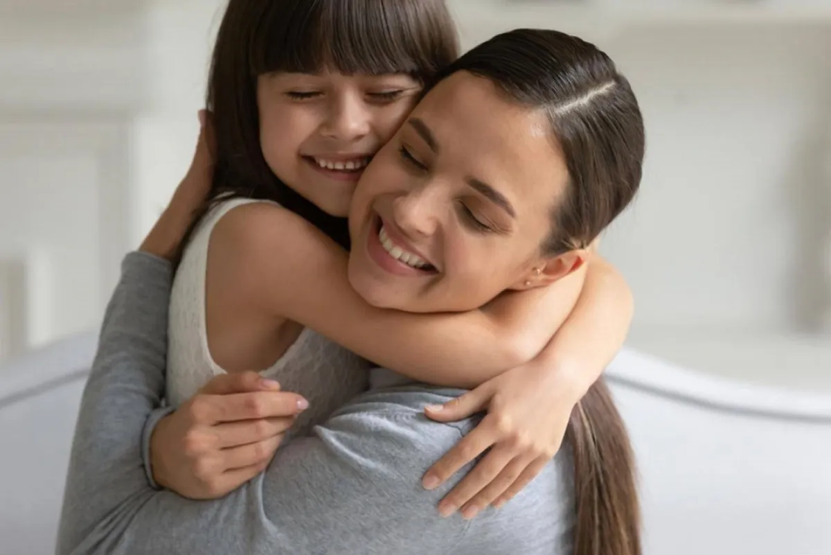 صورة لطفلة تعانق أمها