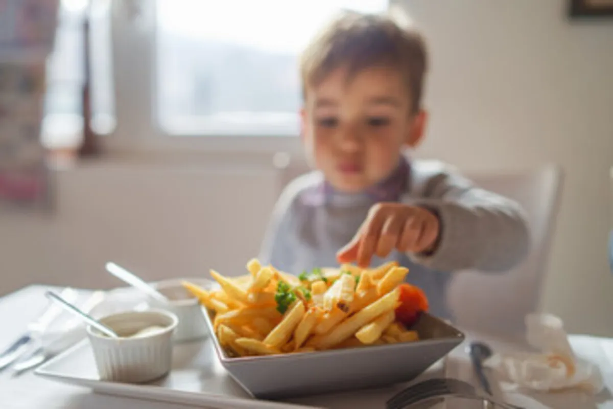 صورة لطفل يستمتع بتناول البطاطس