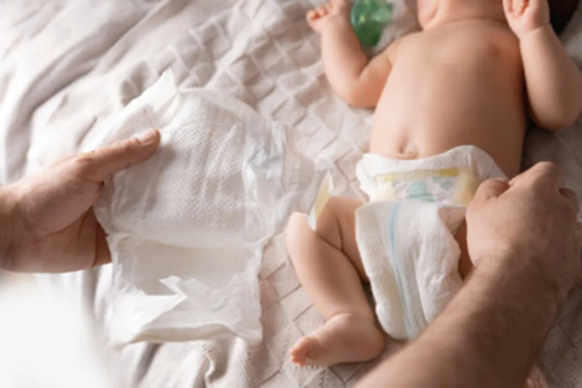 صورة لأم تقوم بتغيير حفاض مولودها