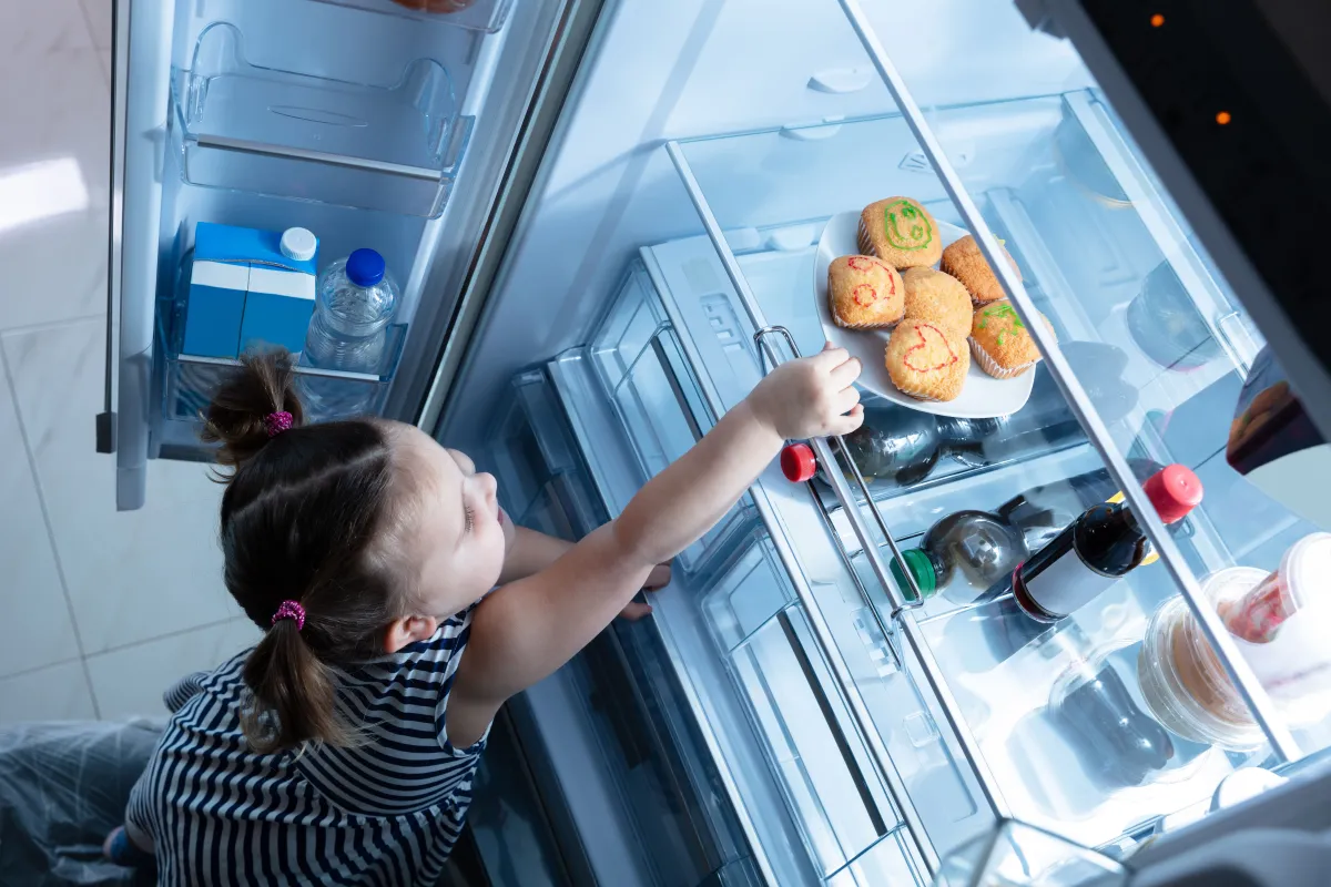 صورة طفلة تفتح الثلاجة