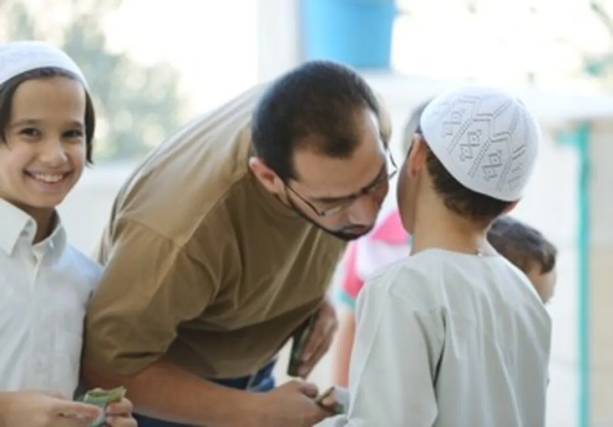 صورة لأب يحتفل مع أطفاله بأول أيام العيد