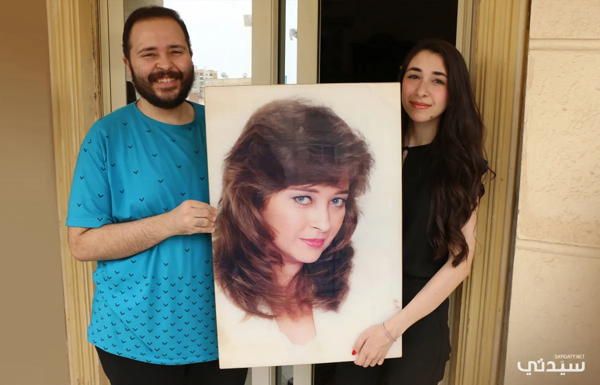 ليلى وشقيقها يوسف منير يحملان صورة والدتهما فايزة كمال- تصوير- عمرو فارس