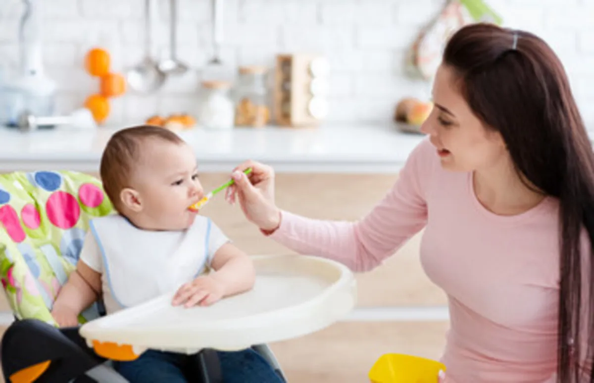 صورة لام تقدم الطعام الصلب لرضيعها